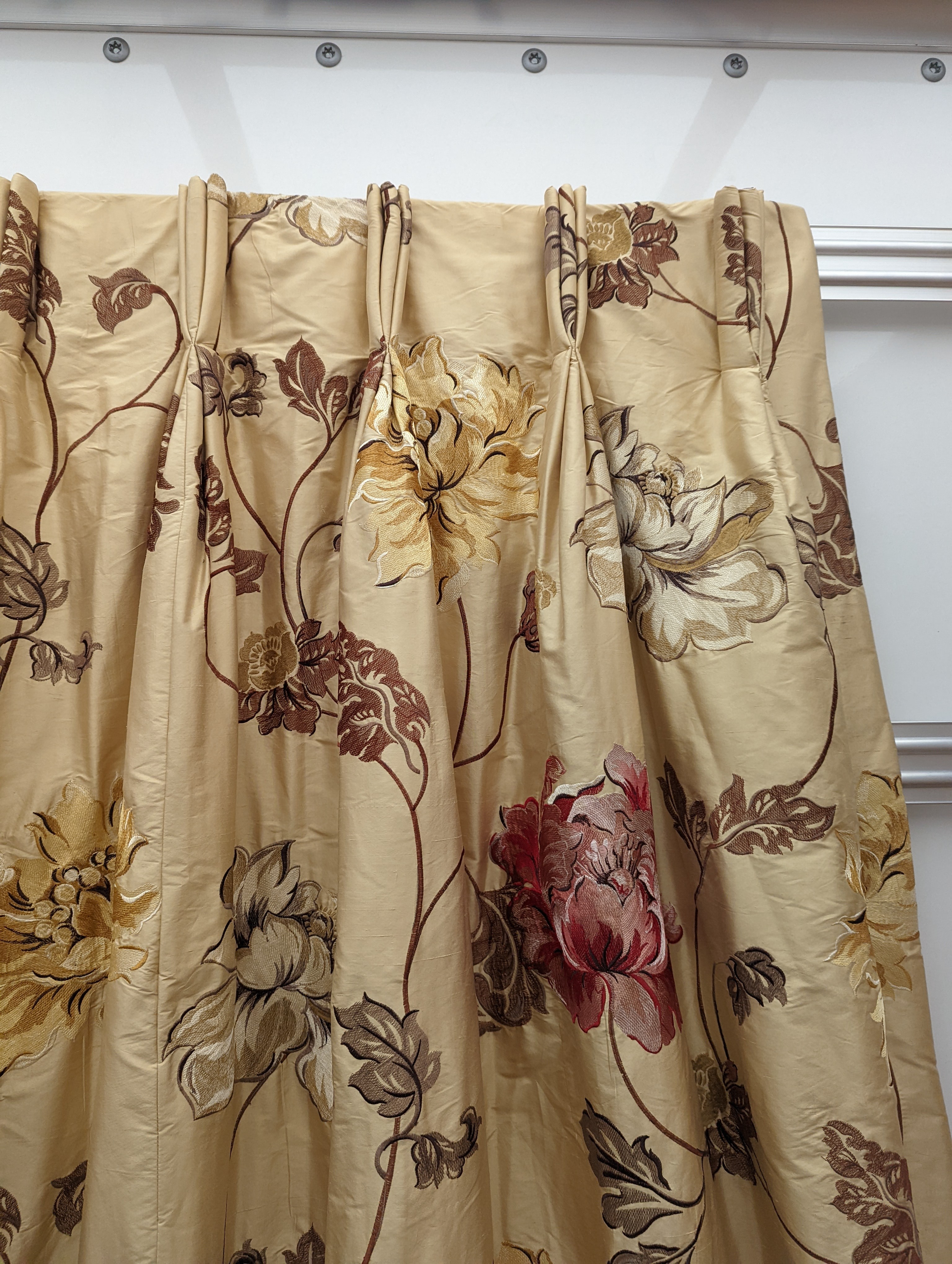 A pair of floral lined curtains. Approximate measurements: Width of top 110cm, Width of bottom 220cm Length 250cm